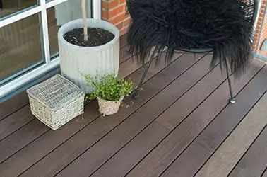 Iclips terrassebeklædning med en potteplante og stol på terrassen 
