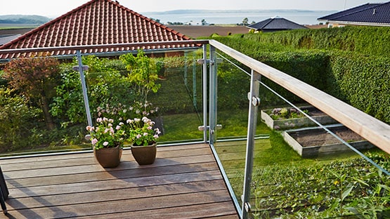 Terrasse med udsigt Terrasse med glasgelænder og fin udsigt til en have og vandet